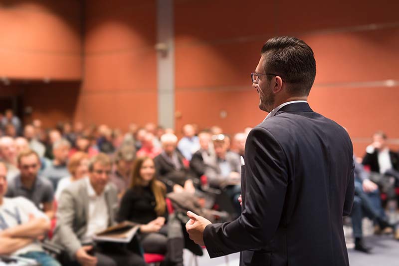 Man speaking to room full of people